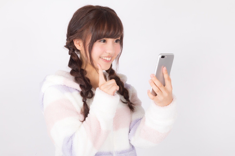 スマートフォンで買い物をする女性