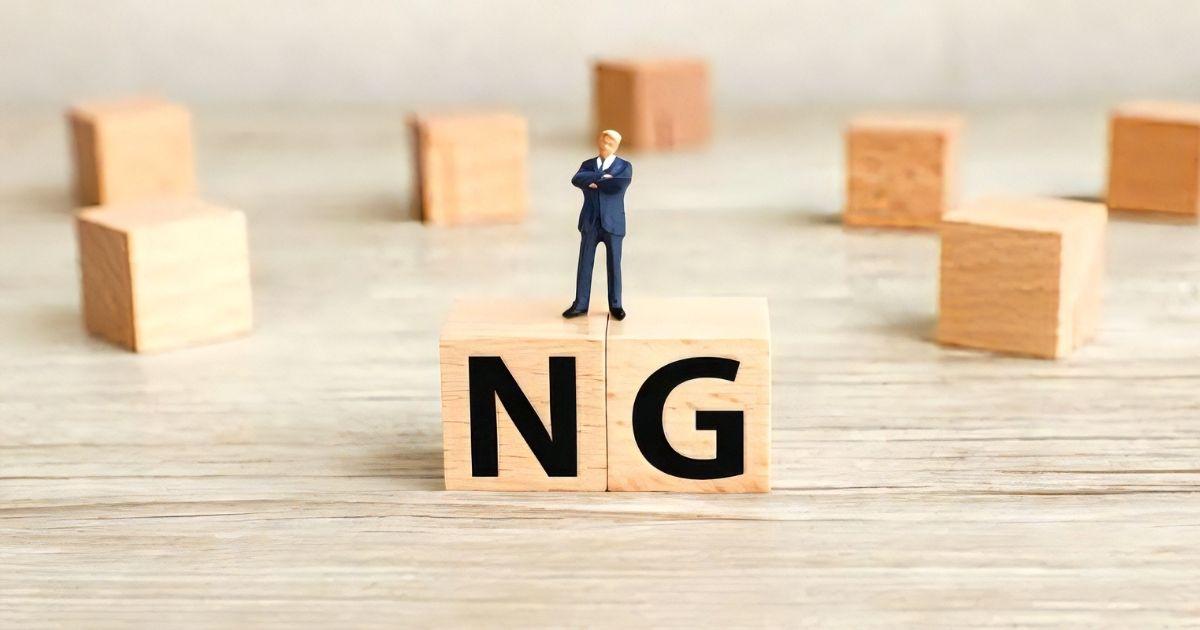 NGの文字が書かれたブロックとミニチュアの男性